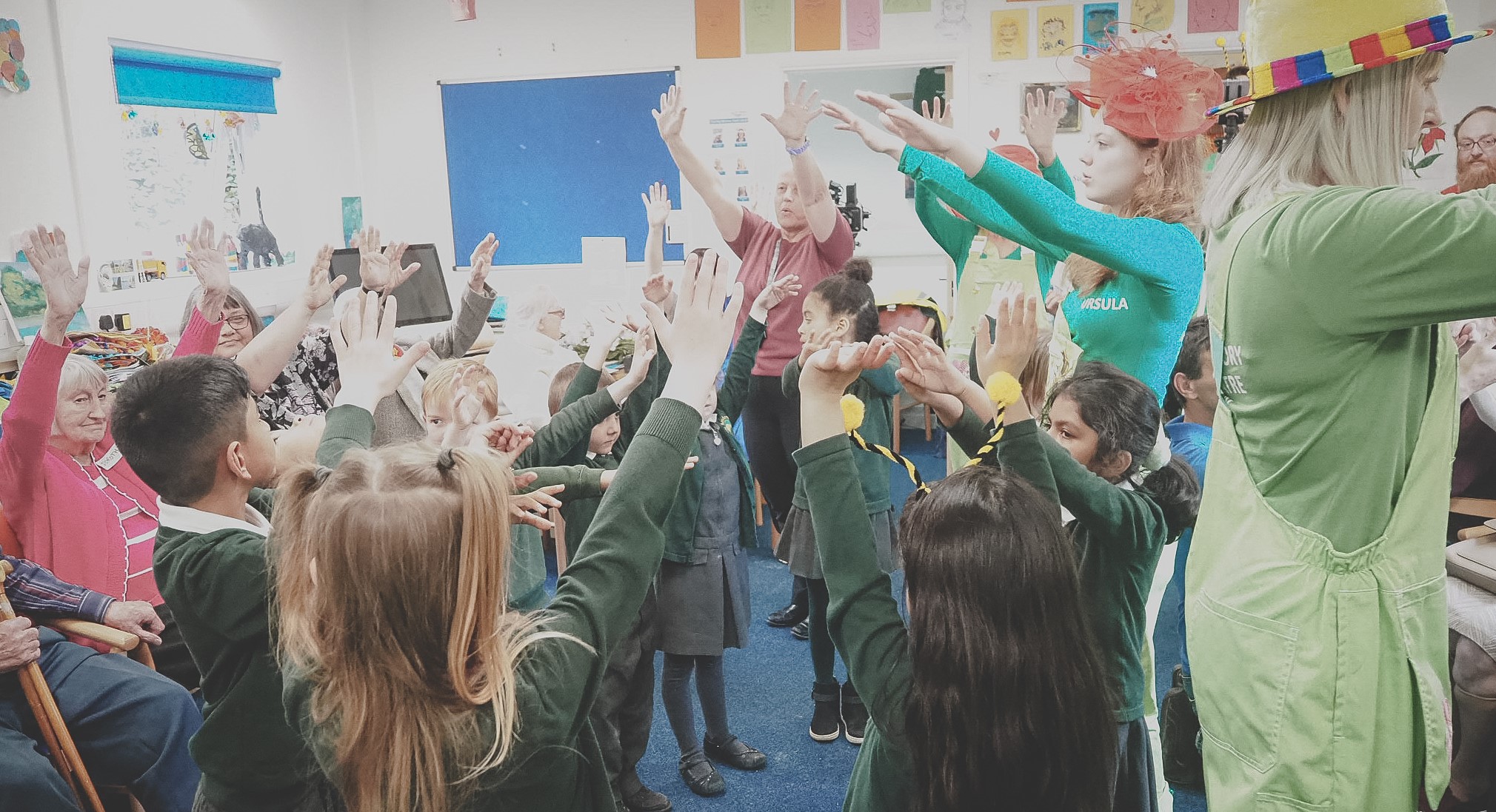 School children dance in a classroom with arms outstretched.