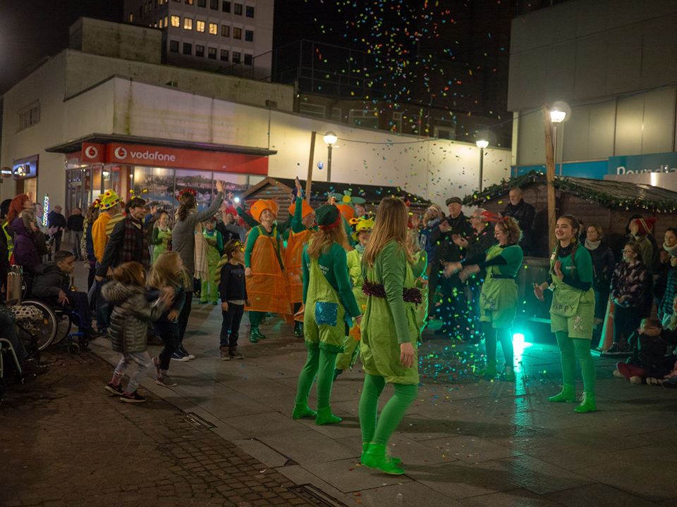 Dancers in green under confetti