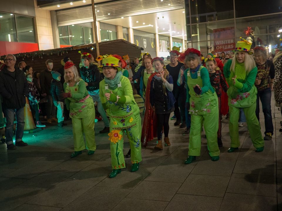 Dancers in green costumes in a shopping centre