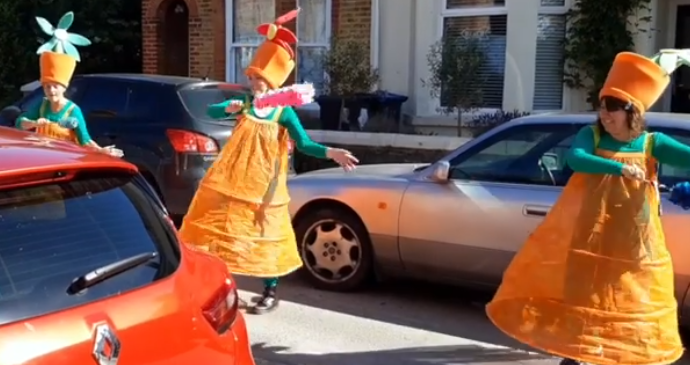 Three colourfully dressed dancers in a road