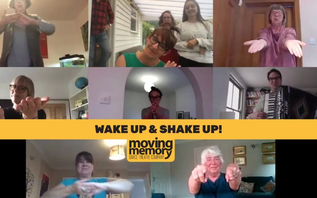 Zoom screen with text "Wake Up & Shake Up!" overlayed. Featuring participants exercising at home with joyful gestures during Moving Memory Dance Theatre Company movement workshop.